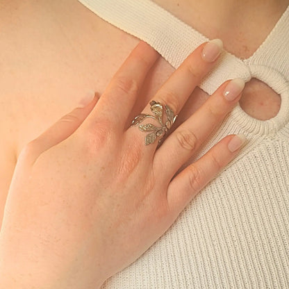 Bague en acier inoxydable argenté ajourée et ajustable, ornée de motifs de feuilles végétales texturées, style nature et élégance.