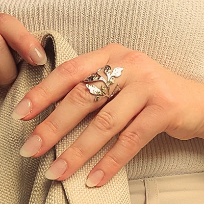 Bague en acier inoxydable argenté ajourée et ajustable, ornée de motifs de feuilles végétales texturées, style nature et élégance.