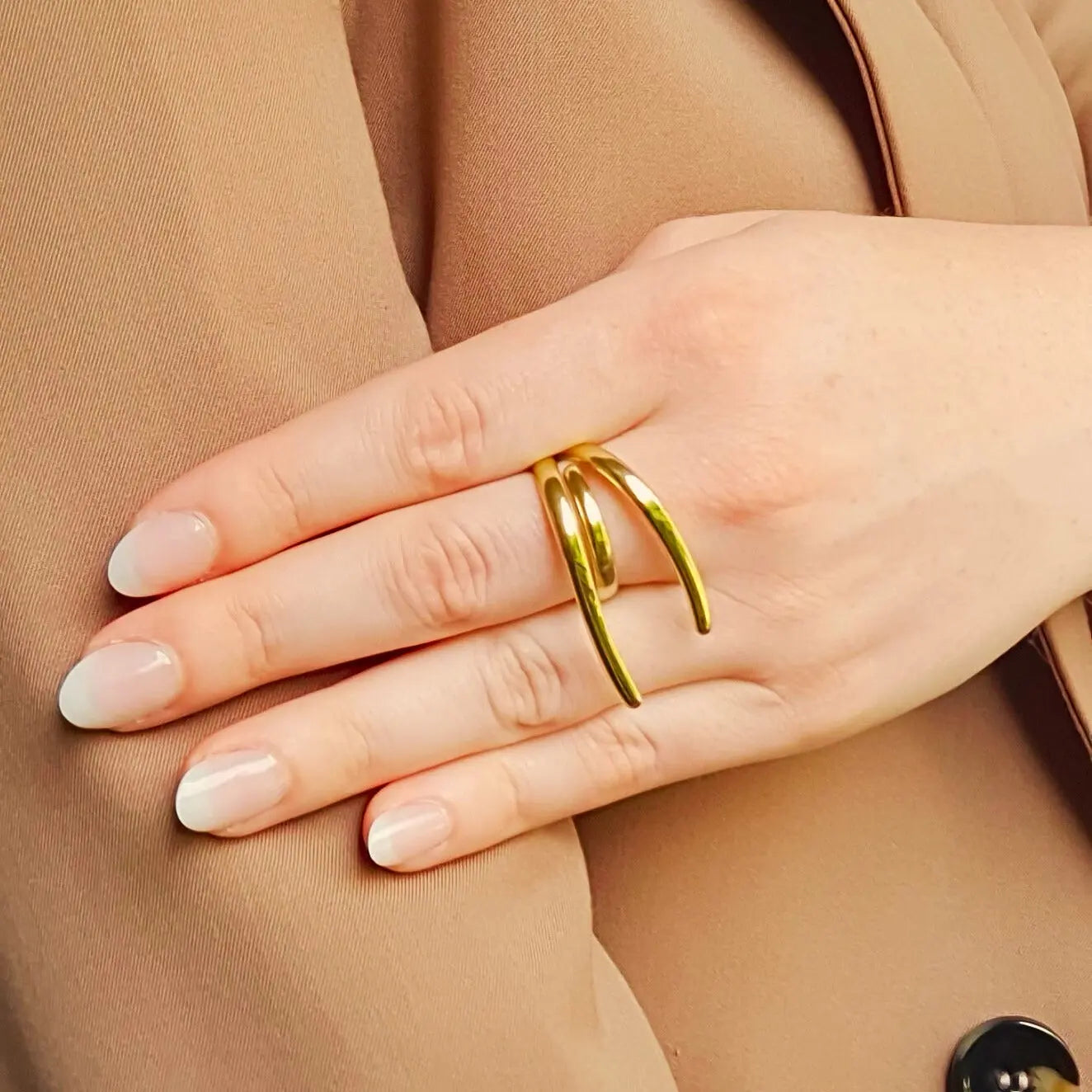 Bague en acier inoxydable doré au design moderne, composée de lignes fluides et organiques qui s’entrelacent avec élégance. 