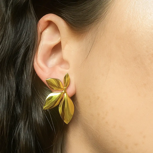 Boucles d’oreilles femme dorées en acier inoxydable hypoallergénique, design feuille pétale fleur bohème et tendance, bijoux Éclosia ajustables et durables. Bijoux boucles d'oreilles végétales portées sur modèle.