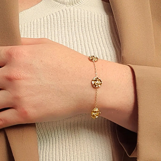 Bracelet doré en acier inoxydable avec trois pendentifs roses ajourées et chaîne fine, réglable, assorti à un collier du même design. Éclosia Bijoux