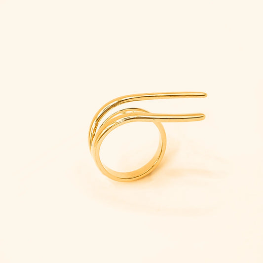 Bague en acier inoxydable doré au design moderne, composée de lignes fluides et organiques qui s’entrelacent avec élégance. 