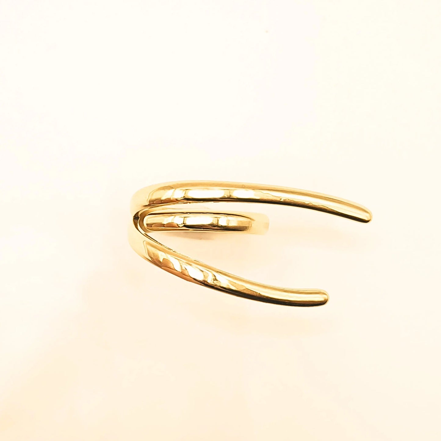 Bague en acier inoxydable doré au design moderne, composée de lignes fluides et organiques qui s’entrelacent avec élégance. 