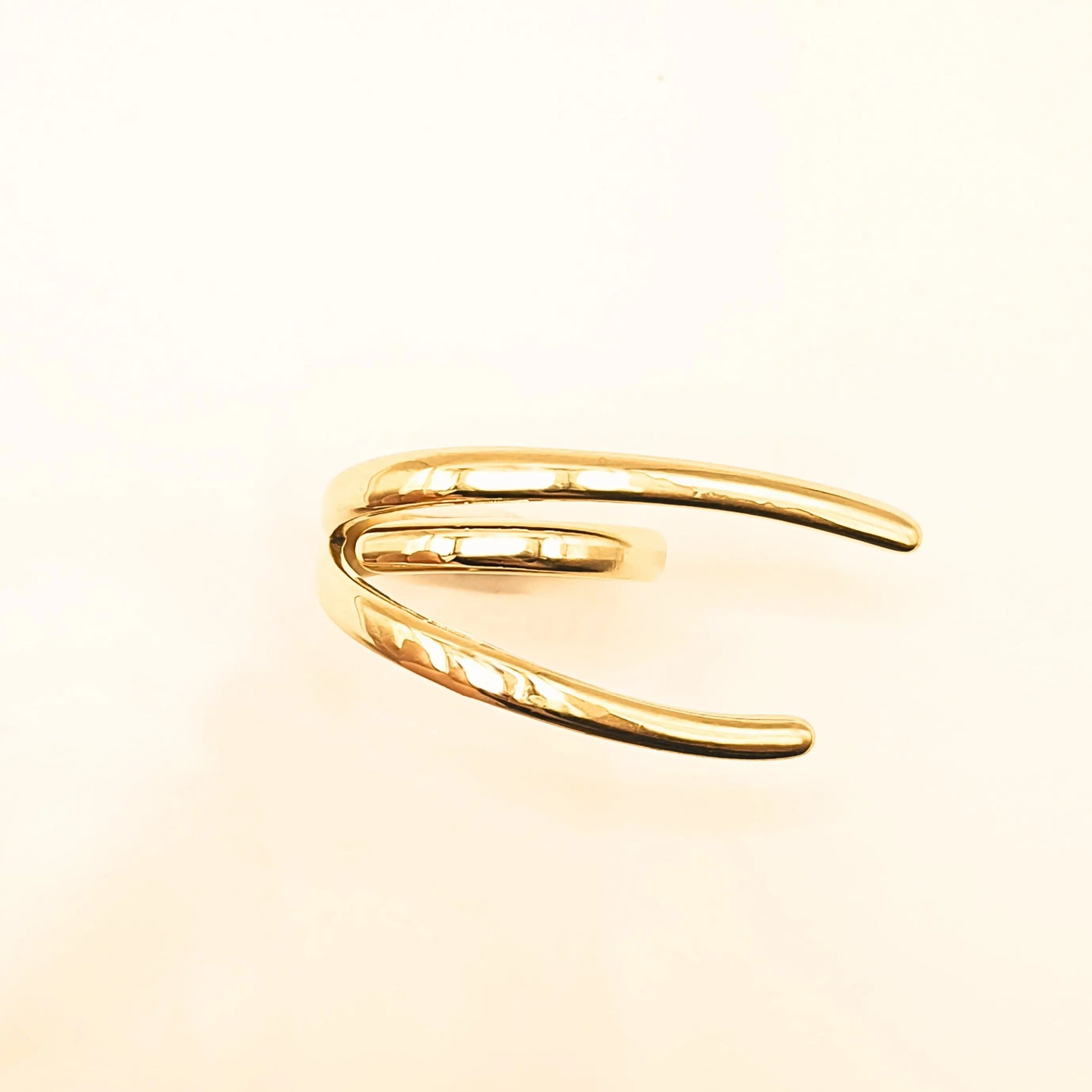 Bague en acier inoxydable doré au design moderne, composée de lignes fluides et organiques qui s’entrelacent avec élégance. 