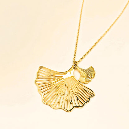 Collier doré en acier inoxydable avec deux pendentifs en fleurs de ginko ajourées et chaîne fine, réglable.