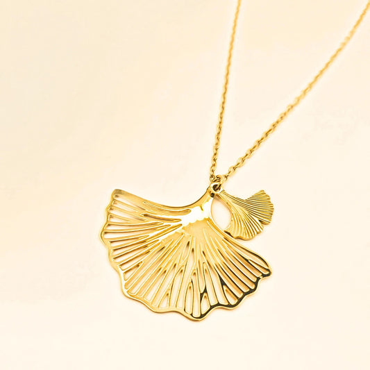 Collier doré en acier inoxydable avec deux pendentifs en fleurs de ginko ajourées et chaîne fine, réglable.