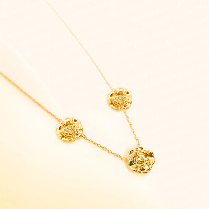 Collier en acier inoxydable en fine chaine dorée ajustable, ornée de 3 fleurs roses avec une petite pierre de zircons, style nature et élégance.